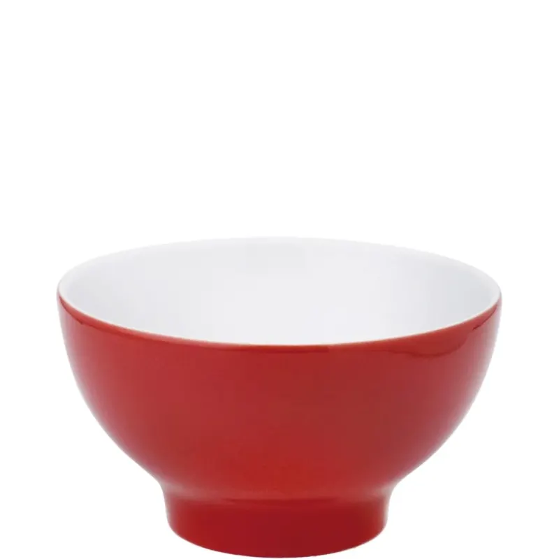 Eine runde Schüssel aus Keramik mit rotem Außenrand und weißem Innenleben. Die Schüssel hat eine schlichte, moderne Form und steht stabil auf einem breiten Fuß. Sie eignet sich für eine Vielzahl von Anwendungen, wie z.B. für Snacks, Salate oder Suppen. Der Kontrast zwischen der roten Außenfarbe und der weißen Innenseite sorgt für ein ansprechendes Aussehen.
