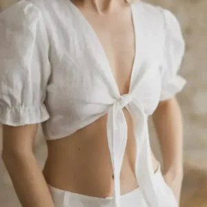 Linen tie-front crop top with puff sleeves and ruffled cuffs, tie detail close-up